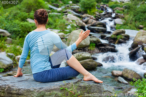 Image of Woman doing Ardha matsyendrasana asana outdoors