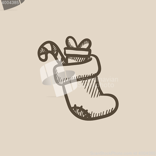 Image of Christmas boot with gift and candy sketch icon.