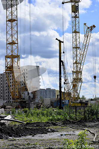 Image of  Construction site with cranes on sky background