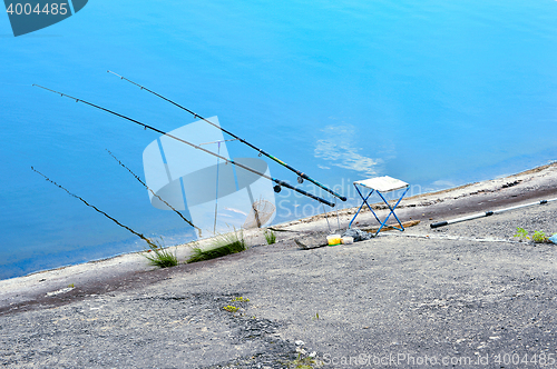 Image of Fishing chair, fishing rods and fishing gear on the lake on a ba