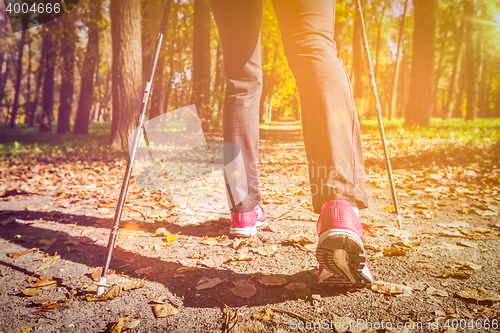 Image of Woman nordic walking outdoors feet close up