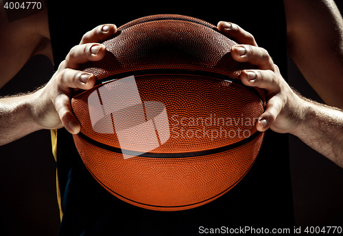 Image of Silhouette view of a basketball player holding basket ball on black background