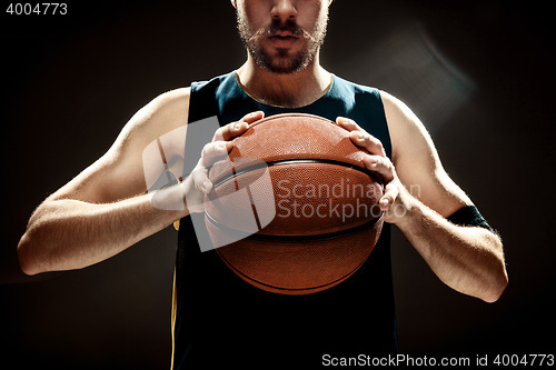 Image of Silhouette view of a basketball player holding basket ball on black background