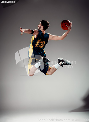 Image of Full length portrait of a basketball player with ball