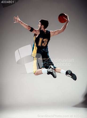 Image of Full length portrait of a basketball player with ball