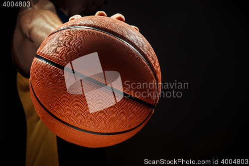 Image of Silhouette view of a basketball player holding basket ball on black background