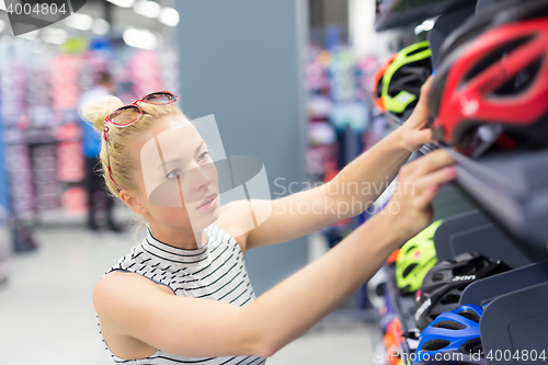 Image of Woman shopping sports equipment in sportswear store.