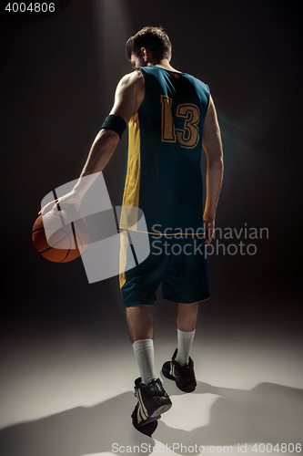 Image of Silhouette view of a basketball player holding basket ball on black background