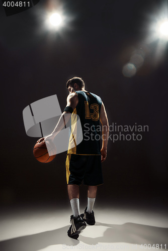 Image of Silhouette view of a basketball player holding basket ball on black background