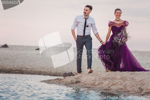 Image of Young romantic couple running on the beach of sea