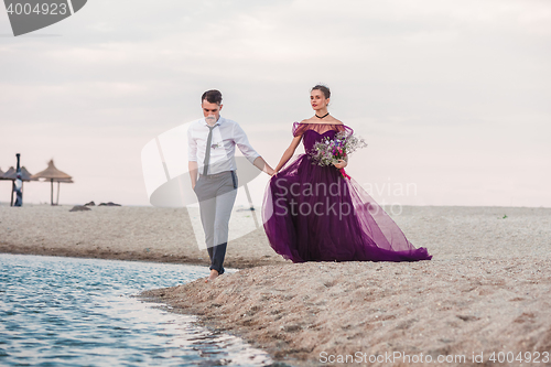 Image of Young romantic couple running on the beach of sea