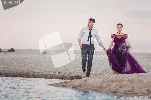 Image of Young romantic couple running on the beach of sea