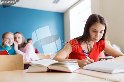 Image of students gossiping behind classmate back at school