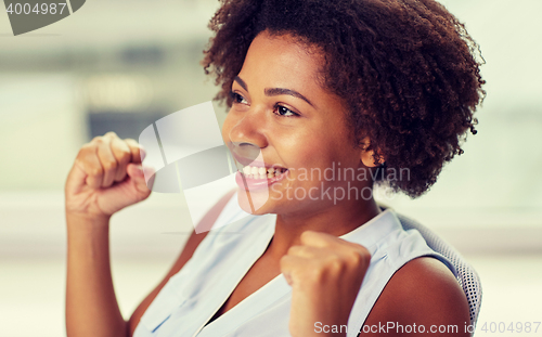 Image of happy african young woman with raised fists