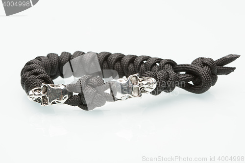 Image of Black braided bracelet with skulls on white background