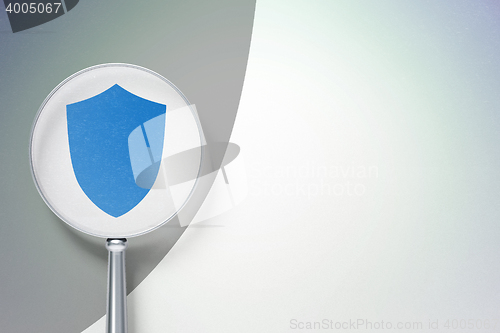 Image of Protection concept:  Shield with optical glass on digital background