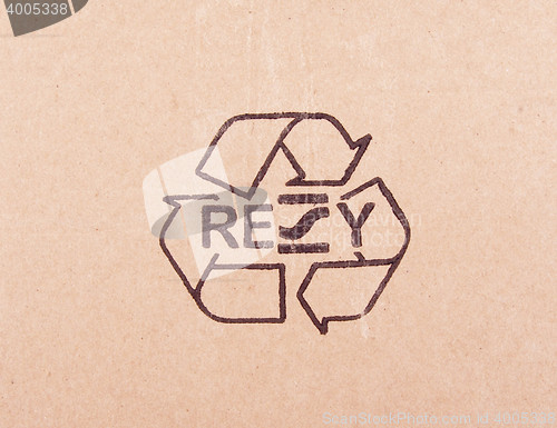 Image of torn out piece of cardboard with recycle symbol