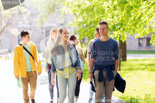 Image of group of happy teenage students walking outdoors