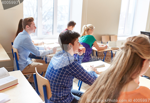 Image of group of students with notebooks at school lesson