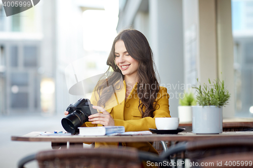 Image of happy tourist woman with camera at city cafe