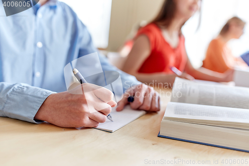 Image of close up of student writing to notebook at school