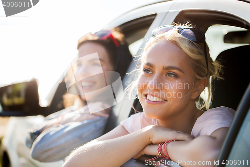 Image of happy teenage girls or women in car at seaside