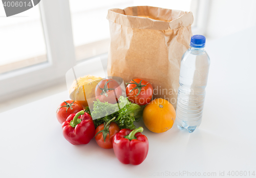 Image of basket of fresh vegetables and water at kitchen