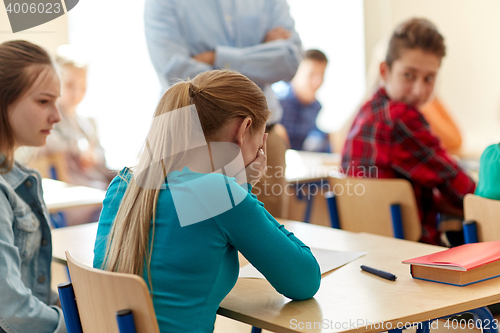 Image of crying student girl with test result and teacher