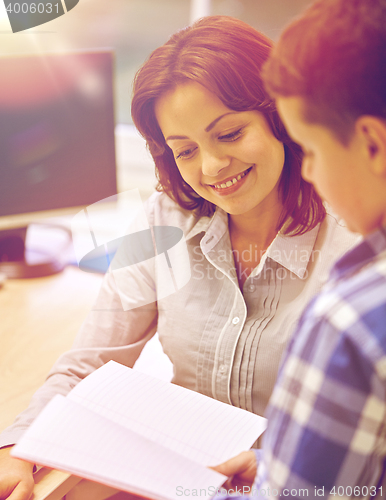 Image of school boy with notebook and teacher in classroom