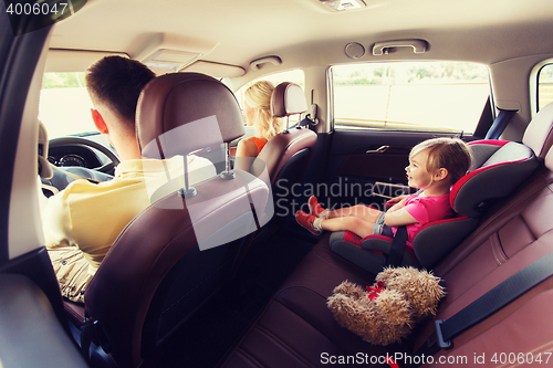 Image of happy parents with little child driving in car