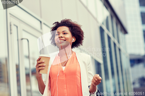 Image of happy african businesswoman with coffee in city