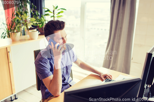 Image of happy creative male worker calling on smarphone