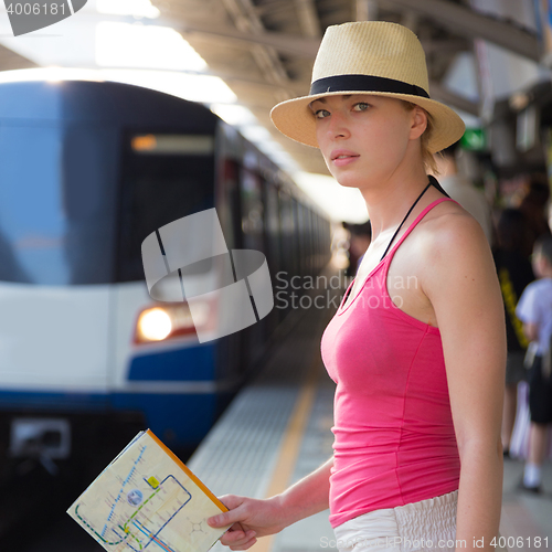 Image of Young woman on platform of railway station.