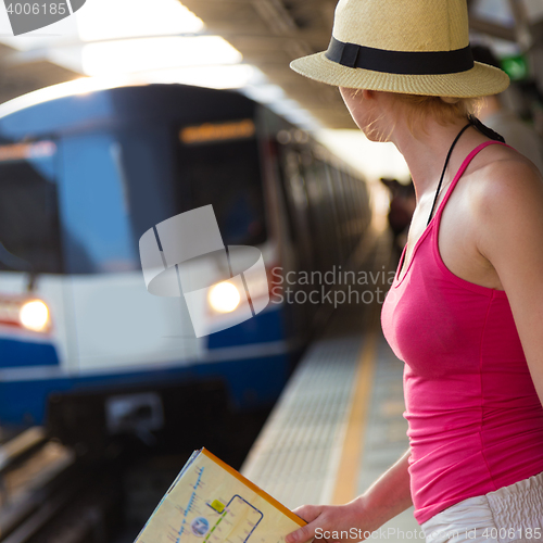 Image of Young woman on platform of railway station.