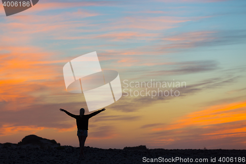 Image of Woman enjoying freedom at sunset.