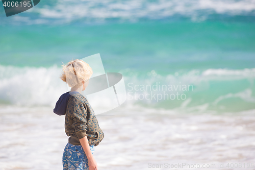 Image of Boy playing with toys on beach.