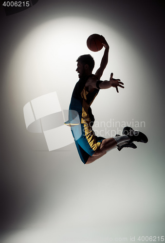 Image of Full length portrait of a basketball player with ball