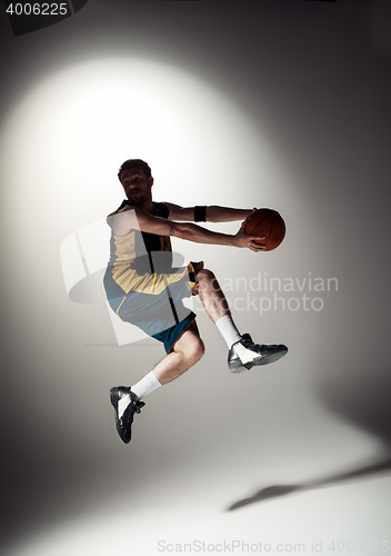 Image of Full length portrait of a basketball player with ball