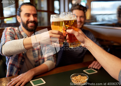 Image of happy male friends drinking beer at bar or pub