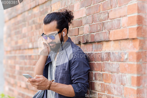 Image of man with earphones and smartphone listening music