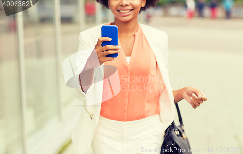 Image of close up of african woman with smartphone in city