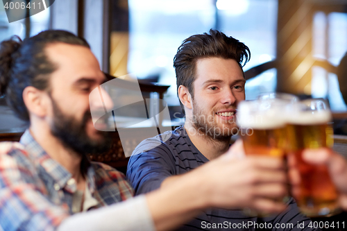 Image of happy male friends drinking beer at bar or pub