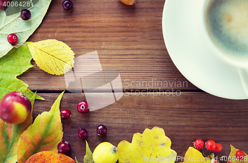 Image of close up of coffee cup on table with autumn leaves