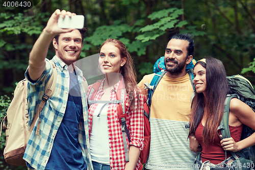 Image of friends with backpack taking selfie by smartphone