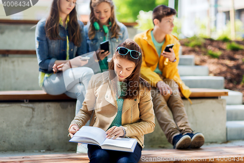 Image of high school student girl reading book outdoors