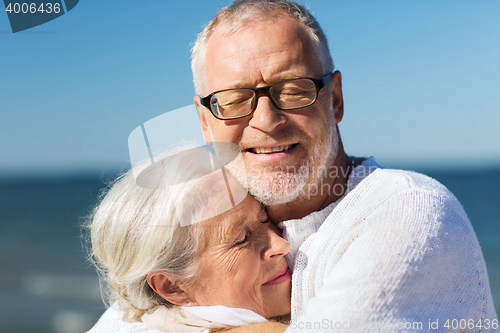 Image of happy senior couple hugging on summer beach