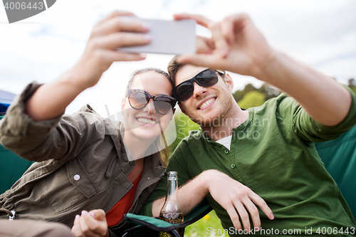 Image of couple of travelers taking selfie by smartphone