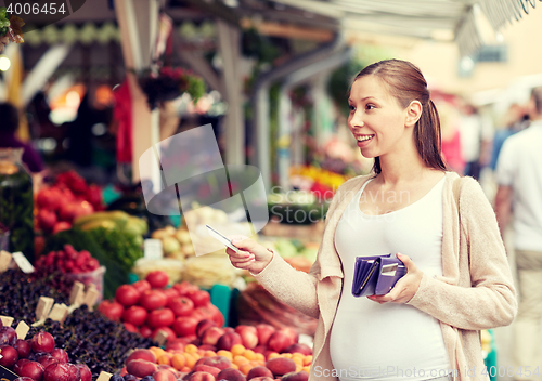 Image of pregnant woman with credit card at street market