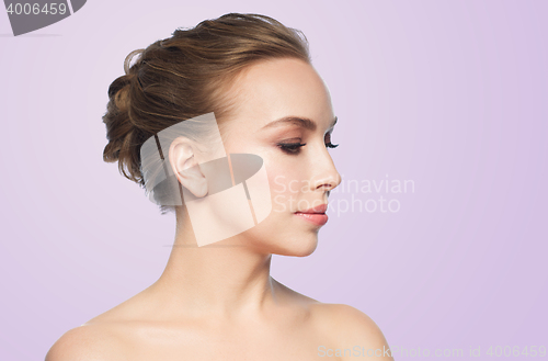 Image of beautiful young woman face over violet background