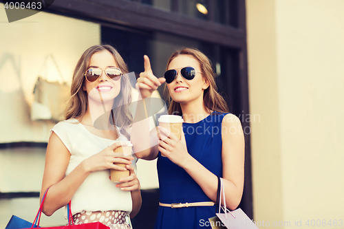 Image of young women with shopping bags and coffee at shop